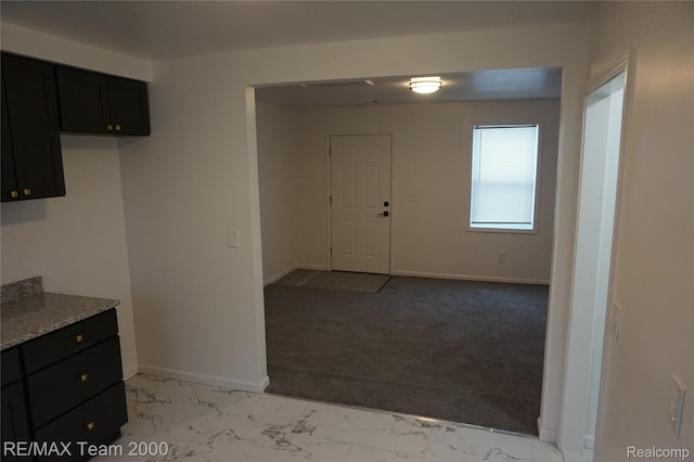26017 Stanford St, Inkster, MI 48141 - kitchen featuring dark cabinetry, light marble finish floors, light carpet, and baseboards