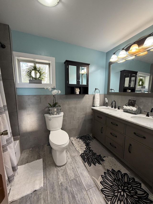 1581 W Lone Pine Dr, Baldwin, MI 49304 - full bath featuring tile walls, toilet, double vanity, wood finished floors, and shower / bath combination with curtain