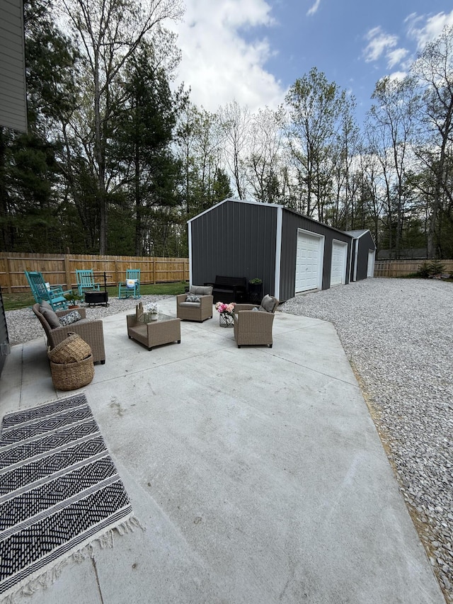 1581 W Lone Pine Dr, Baldwin, MI 49304 - view of patio featuring an outdoor hangout area, an outdoor structure, view of wooded area, and a detached garage