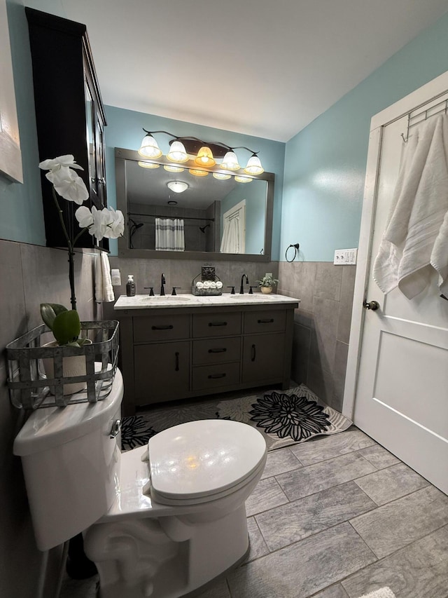 1581 W Lone Pine Dr, Baldwin, MI 49304 - full bath with tile walls, toilet, double vanity, and wainscoting