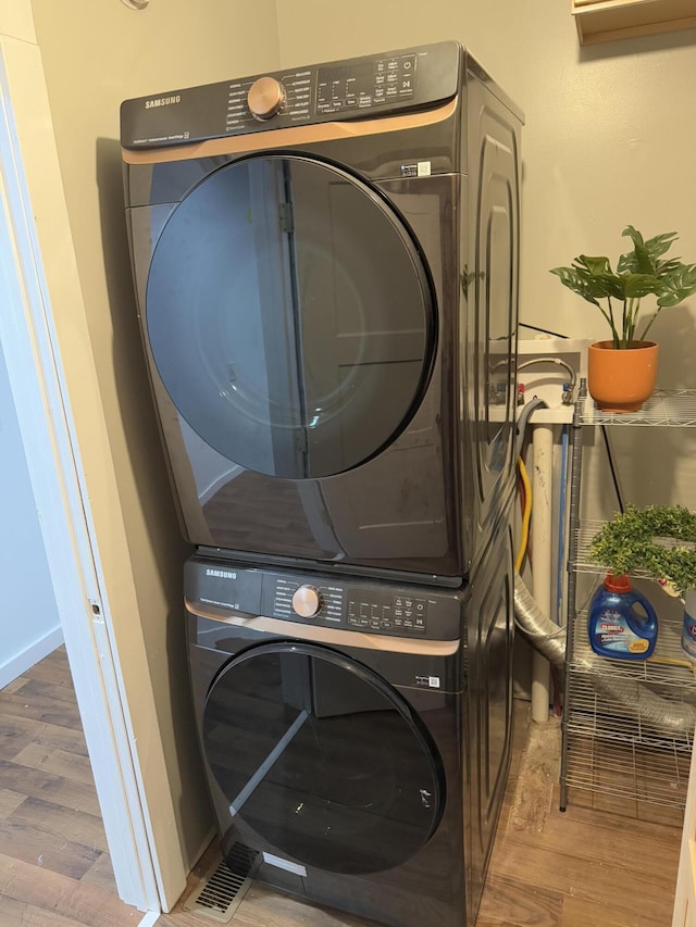 1581 W Lone Pine Dr, Baldwin, MI 49304 - laundry area with stacked washer / drying machine and wood finished floors