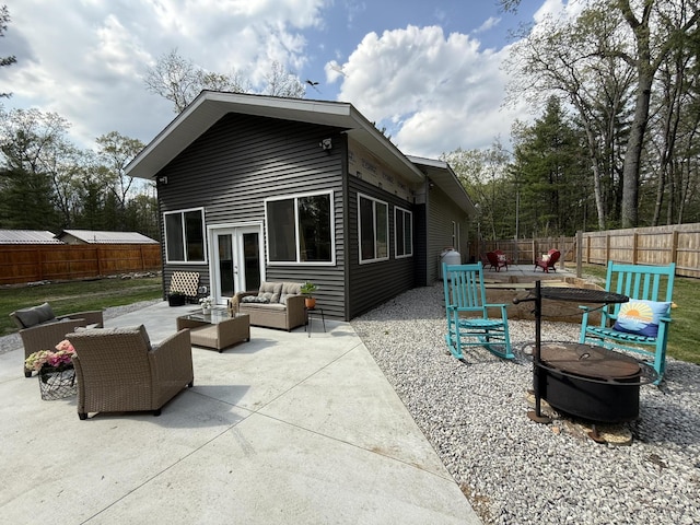 1581 W Lone Pine Dr, Baldwin, MI 49304 - back of house featuring an outdoor living space with a fire pit, a patio area, a fenced backyard, and french doors
