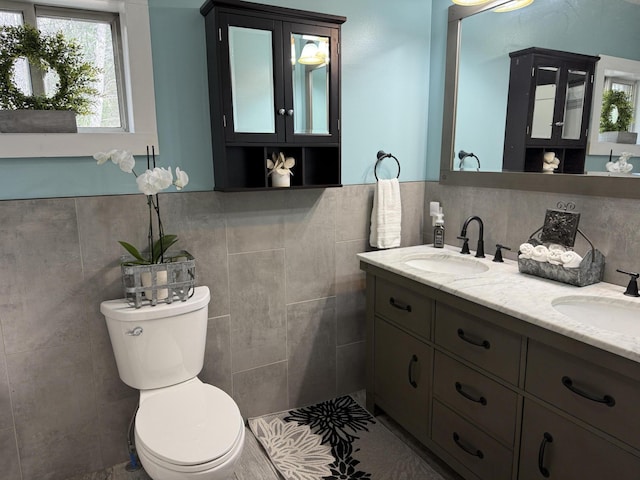 1581 W Lone Pine Dr, Baldwin, MI 49304 - full bathroom with tile walls, double vanity, toilet, and tile patterned floors