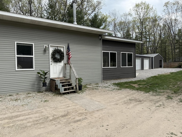 1581 W Lone Pine Dr, Baldwin, MI 49304 - rear view of house featuring entry steps, a detached garage, and an outbuilding