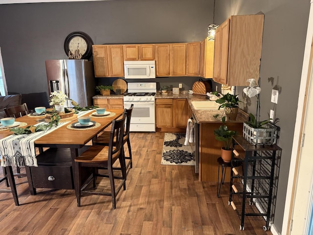 1581 W Lone Pine Dr, Baldwin, MI 49304 - kitchen featuring white appliances, wood finished floors, hanging light fixtures, and a sink