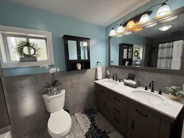 1581 W Lone Pine Dr, Baldwin, MI 49304 - full bathroom with tile walls, toilet, double vanity, a shower with shower curtain, and tile patterned flooring