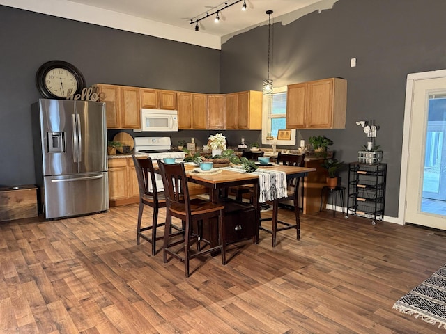 1581 W Lone Pine Dr, Baldwin, MI 49304 - kitchen featuring white appliances, a towering ceiling, track lighting, wood finished floors, and light countertops