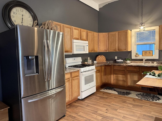 1581 W Lone Pine Dr, Baldwin, MI 49304 - kitchen with white appliances, a sink, light wood-type flooring, hanging light fixtures, and a towering ceiling