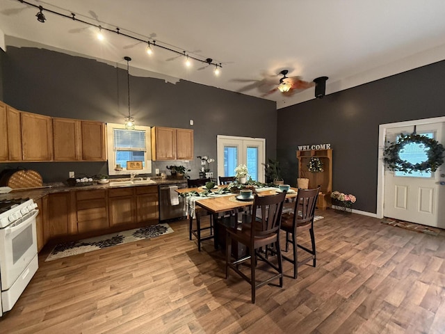 1581 W Lone Pine Dr, Baldwin, MI 49304 - kitchen featuring rail lighting, white gas stove, dishwasher, ceiling fan, and high vaulted ceiling