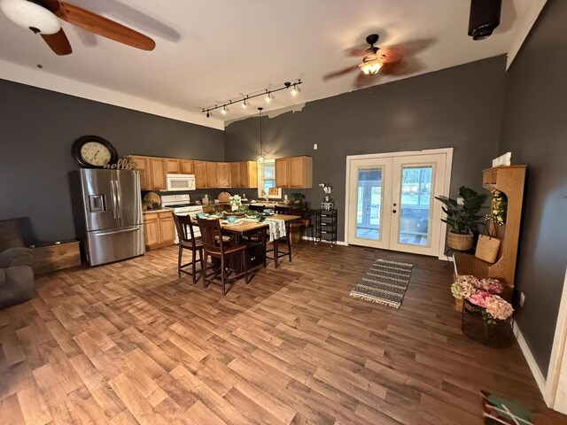 1581 W Lone Pine Dr, Baldwin, MI 49304 - dining space featuring a ceiling fan, track lighting, wood finished floors, a high ceiling, and french doors