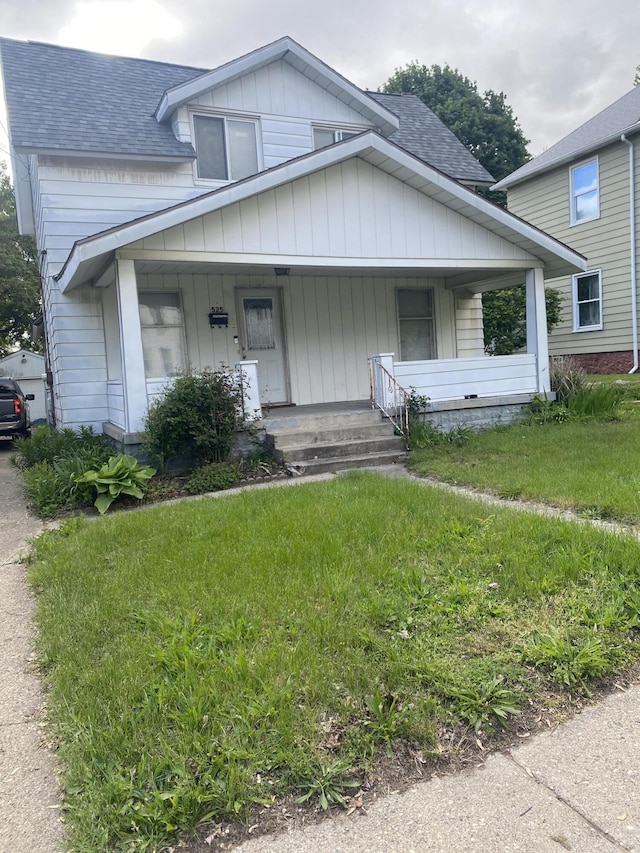 525 NE Eastern Ave NE, Grand Rapids, MI 49503 - bungalow-style home featuring roof with shingles, a porch, and a front lawn