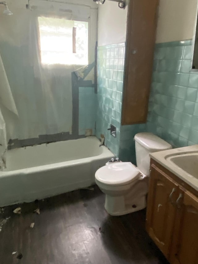 525 NE Eastern Ave NE, Grand Rapids, MI 49503 - bathroom with tile walls, vanity, wood finished floors, toilet, and shower / bathtub combination with curtain