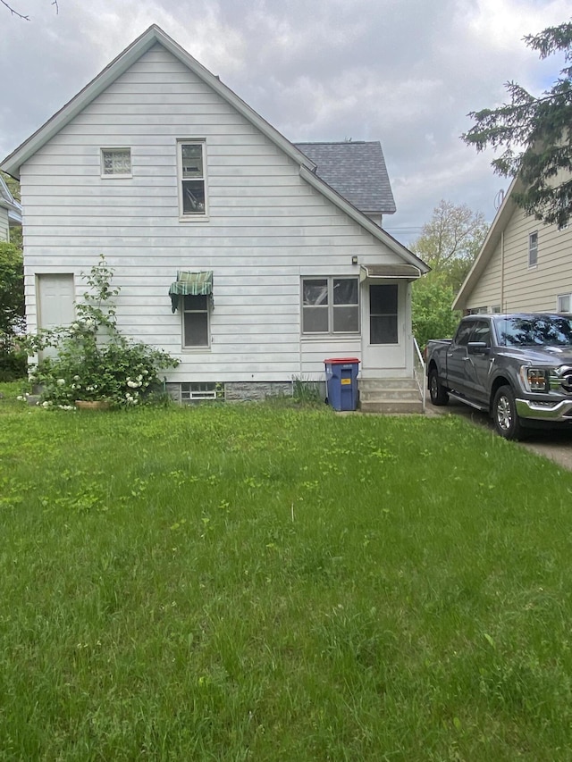525 NE Eastern Ave NE, Grand Rapids, MI 49503 - view of home's exterior featuring roof with shingles, a lawn, and entry steps