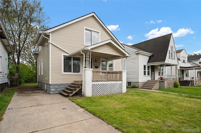 18666 Carrie St, Hamtramck, MI 48234 - view of front of house featuring a porch, a front lawn, and a shingled roof