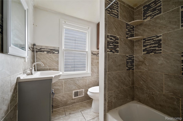 18666 Carrie St, Hamtramck, MI 48234 - full bathroom featuring tile walls, vanity, toilet, shower / tub combination, and tile patterned floors