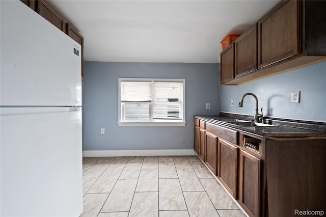 18666 Carrie St, Hamtramck, MI 48234 - kitchen with freestanding refrigerator, a sink, dark brown cabinetry, and baseboards