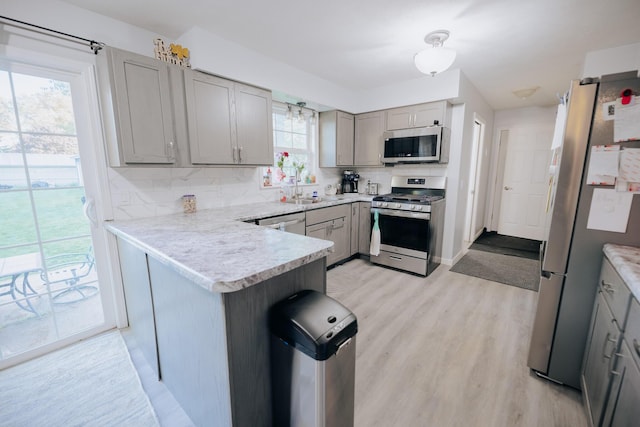 1905 Ora St, Muskegon, MI 49445 - kitchen with stainless steel appliances, gray cabinetry, light countertops, a sink, and light wood finished floors