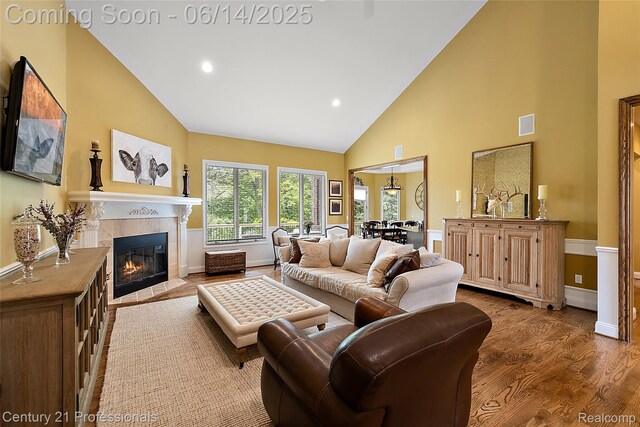 1181 Iroquois Trl, Oxford, MI 48371 - living room with high vaulted ceiling, a tiled fireplace, wood finished floors, and recessed lighting