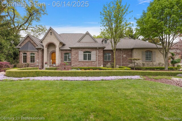 1181 Iroquois Trl, Oxford, MI 48371 - french country home featuring a front lawn, brick siding, and roof with shingles