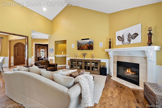 1181 Iroquois Trl, Oxford, MI 48371 - living area featuring wood finished floors, a tile fireplace, a wainscoted wall, and a high ceiling