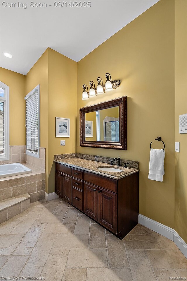 1181 Iroquois Trl, Oxford, MI 48371 - full bath with stone tile floors, vanity, and a bath