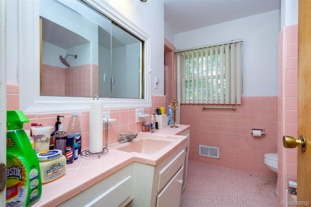 25547 Jennifer St, Redford, MI 48239 - full bath featuring vanity, tile walls, toilet, a wainscoted wall, and a shower