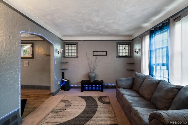 12518 Corbett St, Hamtramck, MI 48213 - living area featuring a textured wall, arched walkways, healthy amount of natural light, and baseboards