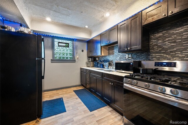 12518 Corbett St, Hamtramck, MI 48213 - kitchen with appliances with stainless steel finishes, a textured ceiling, a sink, light countertops, and decorative backsplash