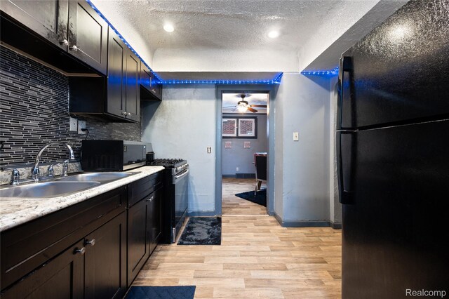 12518 Corbett St, Hamtramck, MI 48213 - kitchen featuring freestanding refrigerator, a sink, gas range, a textured ceiling, and decorative backsplash