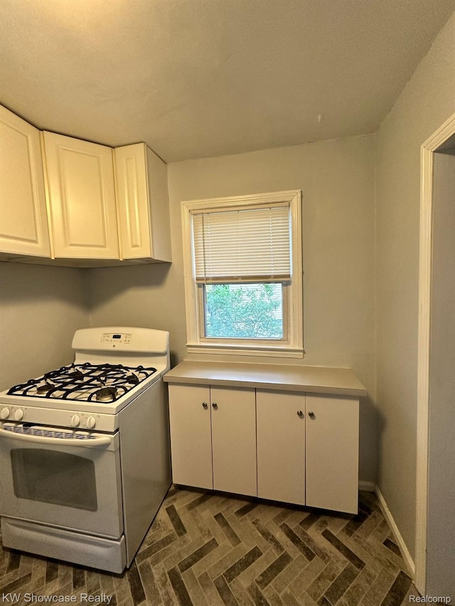 459 E Breckenridge St, Ferndale, MI 48220 - kitchen featuring white gas stove, white cabinets, light countertops, and baseboards