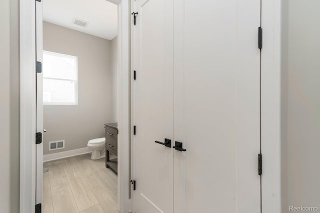 1439 Merry Rd, Waterford, MI 48328 - bathroom with wood finished floors, baseboards, toilet, and vanity