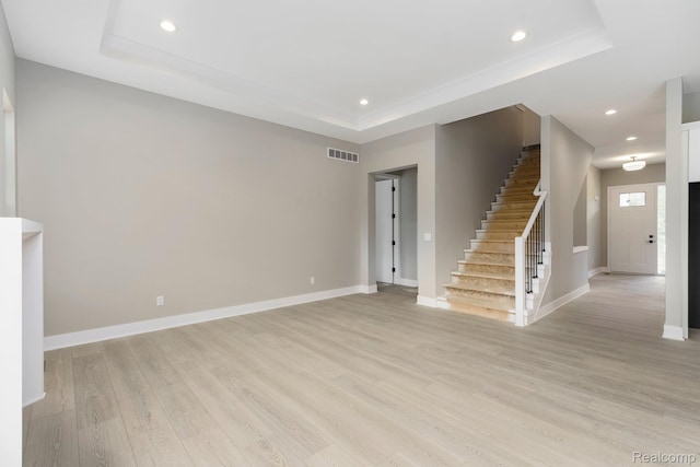 1439 Merry Rd, Waterford, MI 48328 - unfurnished living room featuring a tray ceiling, stairs, light wood finished floors, recessed lighting, and baseboards