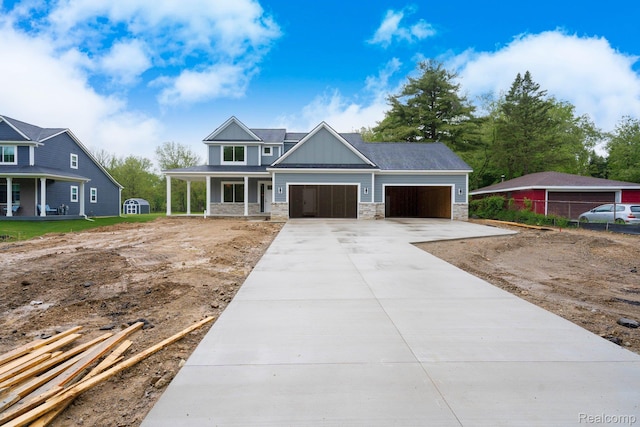 1439 Merry Rd, Waterford, MI 48328 - view of front of house with covered porch, driveway, a garage, board and batten siding, and stone siding