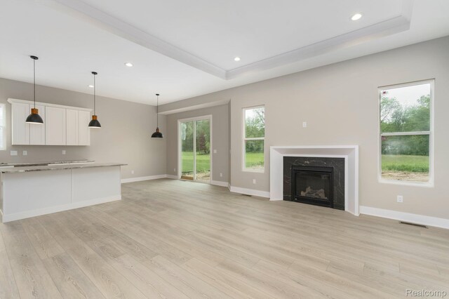 1439 Merry Rd, Waterford, MI 48328 - unfurnished living room with light wood-type flooring, baseboards, recessed lighting, a premium fireplace, and a raised ceiling
