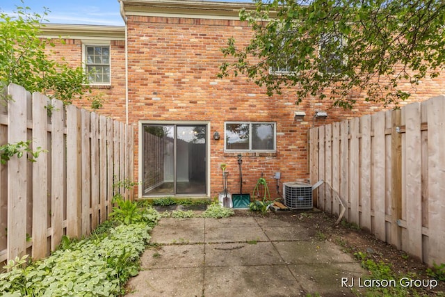 2463 Abbington Dr SE, Grand Rapids, MI 49506 - rear view of house featuring central AC unit, brick siding, and a patio