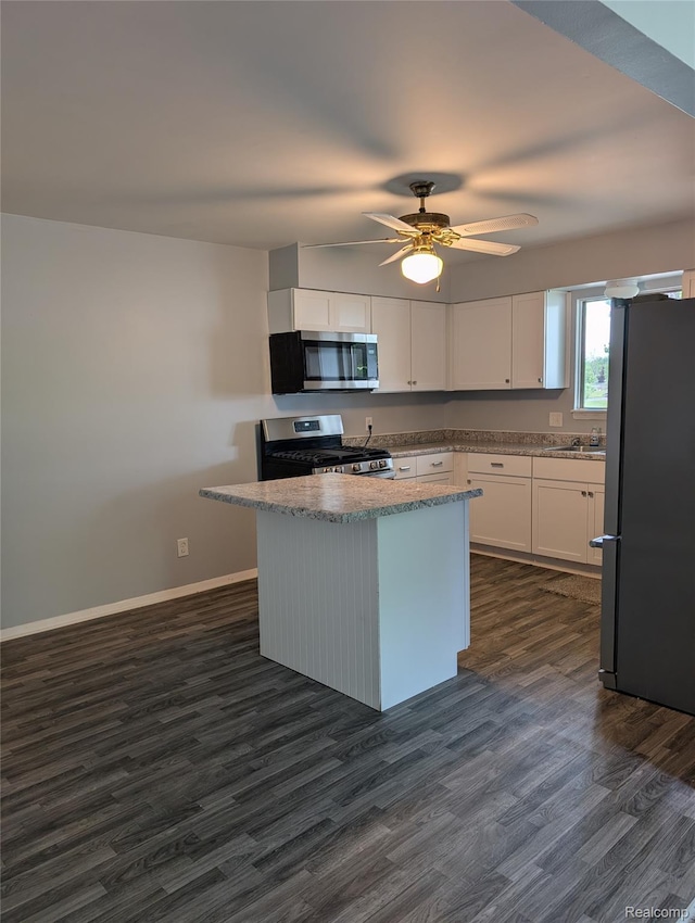 190 Main St, Sebewaing, MI 48759 - kitchen with stainless steel appliances, dark wood finished floors, white cabinets, and light stone countertops