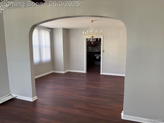 8419 Paige, Warren, MI 48089 - unfurnished dining area featuring dark wood-type flooring, baseboards, and arched walkways