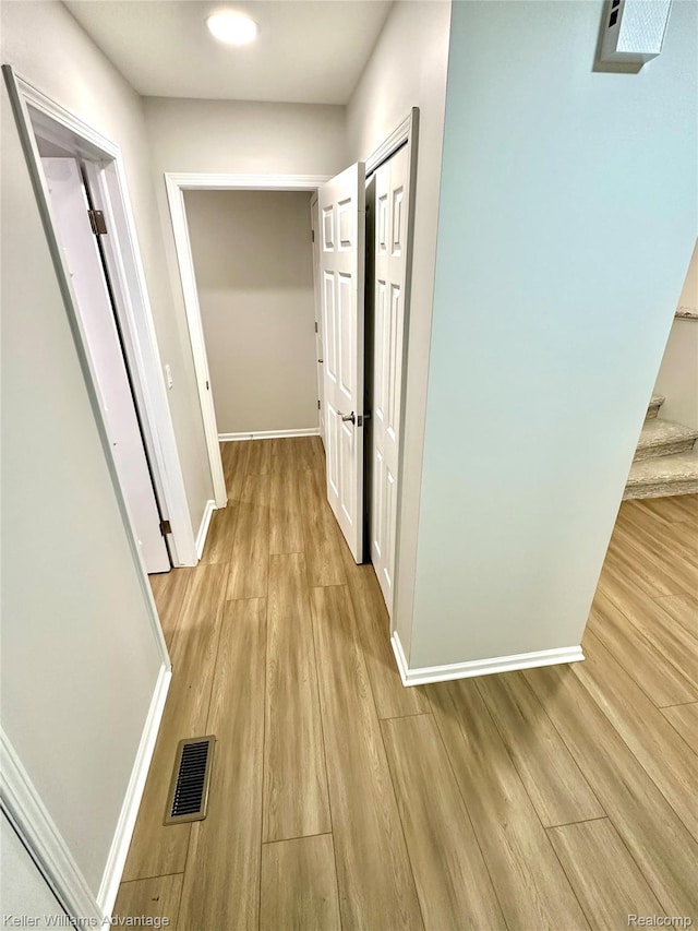 31404 Hunters Circle Dr, Farmington, MI 48334 - hallway featuring baseboards, light wood finished floors, and stairs