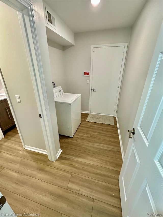 31404 Hunters Circle Dr, Farmington, MI 48334 - laundry area featuring washer / dryer, light wood-style flooring, and baseboards