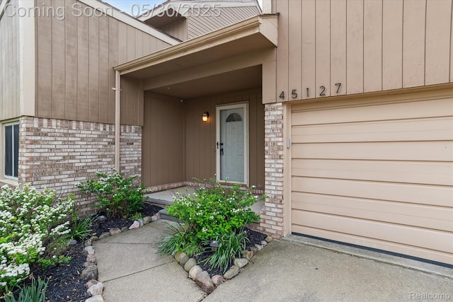 45127 Fair Oaks Dr, Canton, MI 48187 - view of exterior entry with an attached garage and brick siding