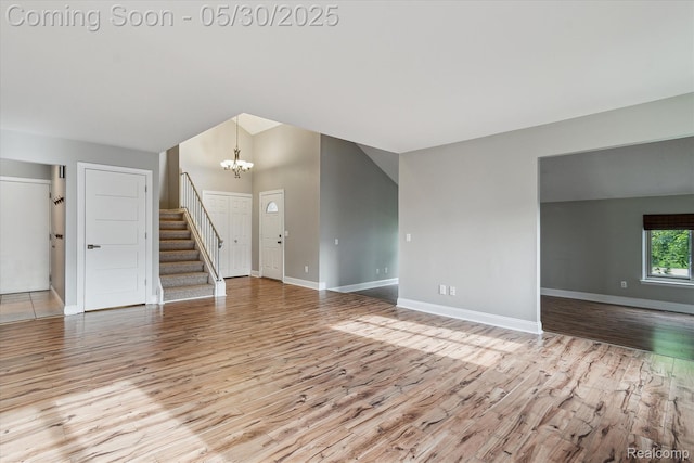 45127 Fair Oaks Dr, Canton, MI 48187 - unfurnished living room with wood finished floors, a chandelier, stairs, baseboards, and lofted ceiling