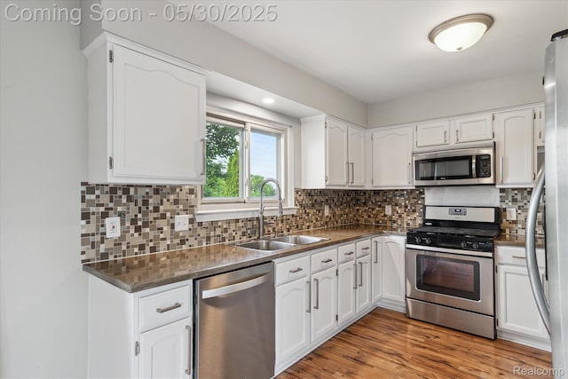 45127 Fair Oaks Dr, Canton, MI 48187 - kitchen featuring appliances with stainless steel finishes, a sink, dark countertops, and white cabinets
