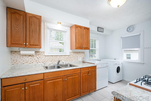 812 Forest St, Ionia, MI 48846 - kitchen with a sink, washing machine and dryer, light countertops, and brown cabinetry