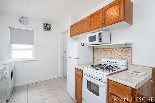 812 Forest St, Ionia, MI 48846 - kitchen featuring white appliances, washer and dryer, brown cabinetry, decorative backsplash, and light countertops