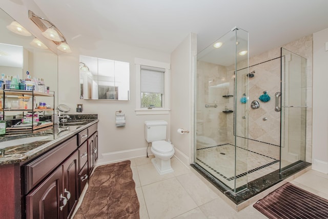 2210 Lindsey Rd, Jackson, MI 49201 - bathroom featuring double vanity, a shower stall, toilet, baseboards, and tile patterned floors