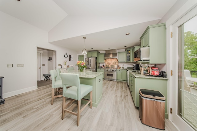 2210 Lindsey Rd, Jackson, MI 49201 - kitchen featuring green cabinets, stainless steel appliances, wall chimney range hood, a breakfast bar area, and light wood-style floors