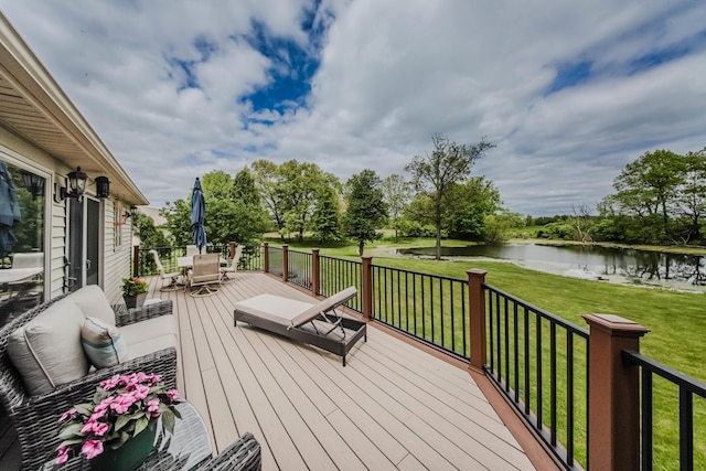 2210 Lindsey Rd, Jackson, MI 49201 - wooden deck with outdoor dining space, a water view, and a lawn