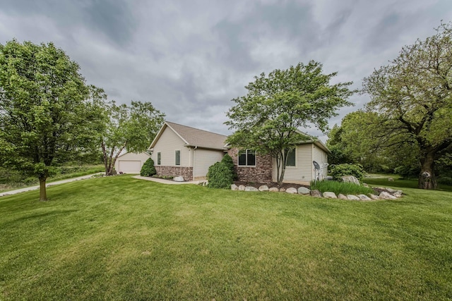 2210 Lindsey Rd, Jackson, MI 49201 - view of home's exterior featuring an outbuilding, a yard, a garage, and brick siding