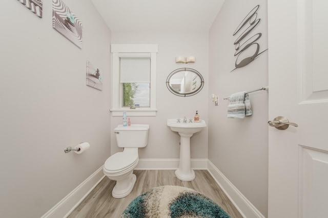 2210 Lindsey Rd, Jackson, MI 49201 - half bathroom with wood finished floors, toilet, and baseboards