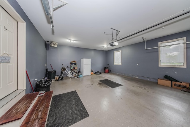 2210 Lindsey Rd, Jackson, MI 49201 - garage featuring a garage door opener and freestanding refrigerator